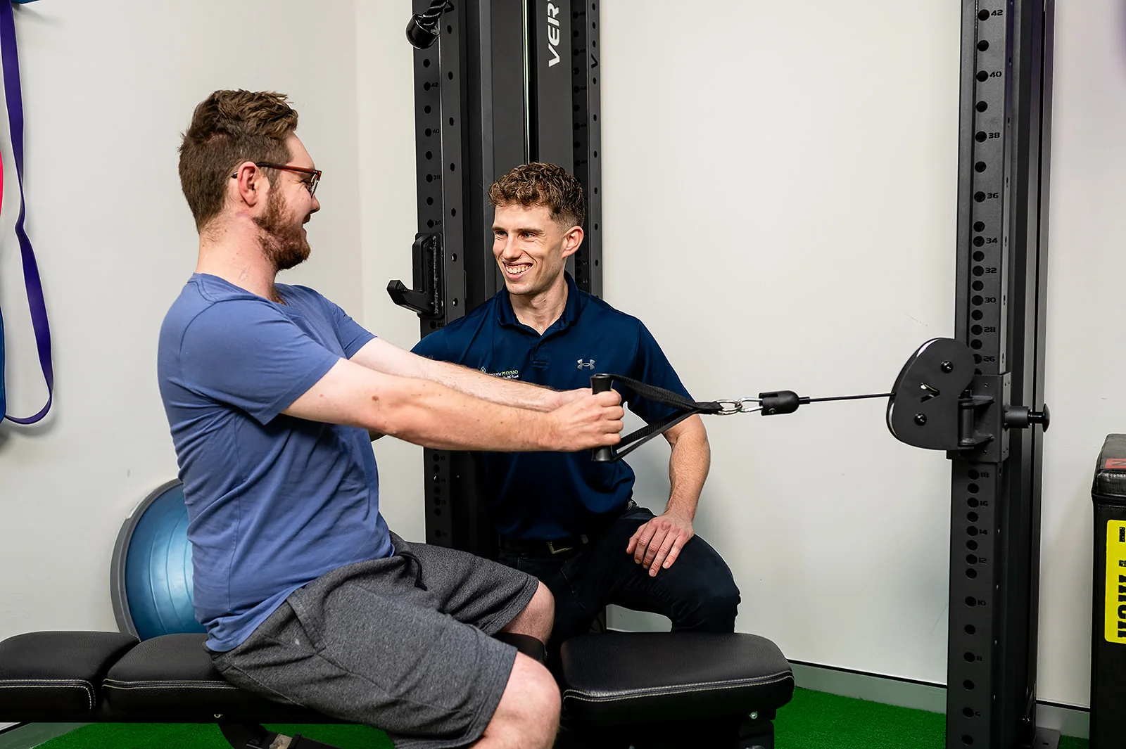 A clinician supervising a seated cable exercise