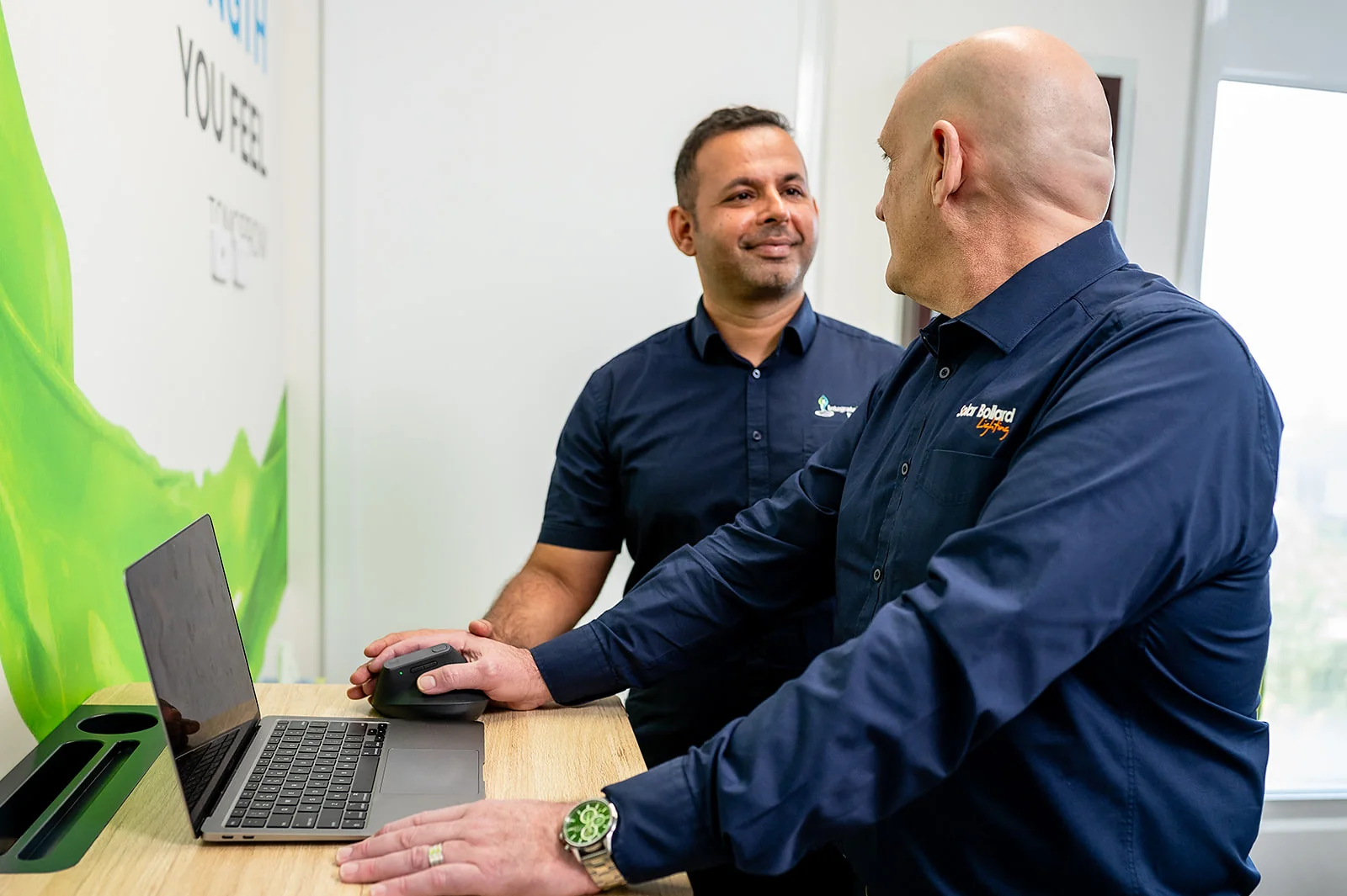 A clinician talking with a patient at a computer workstation